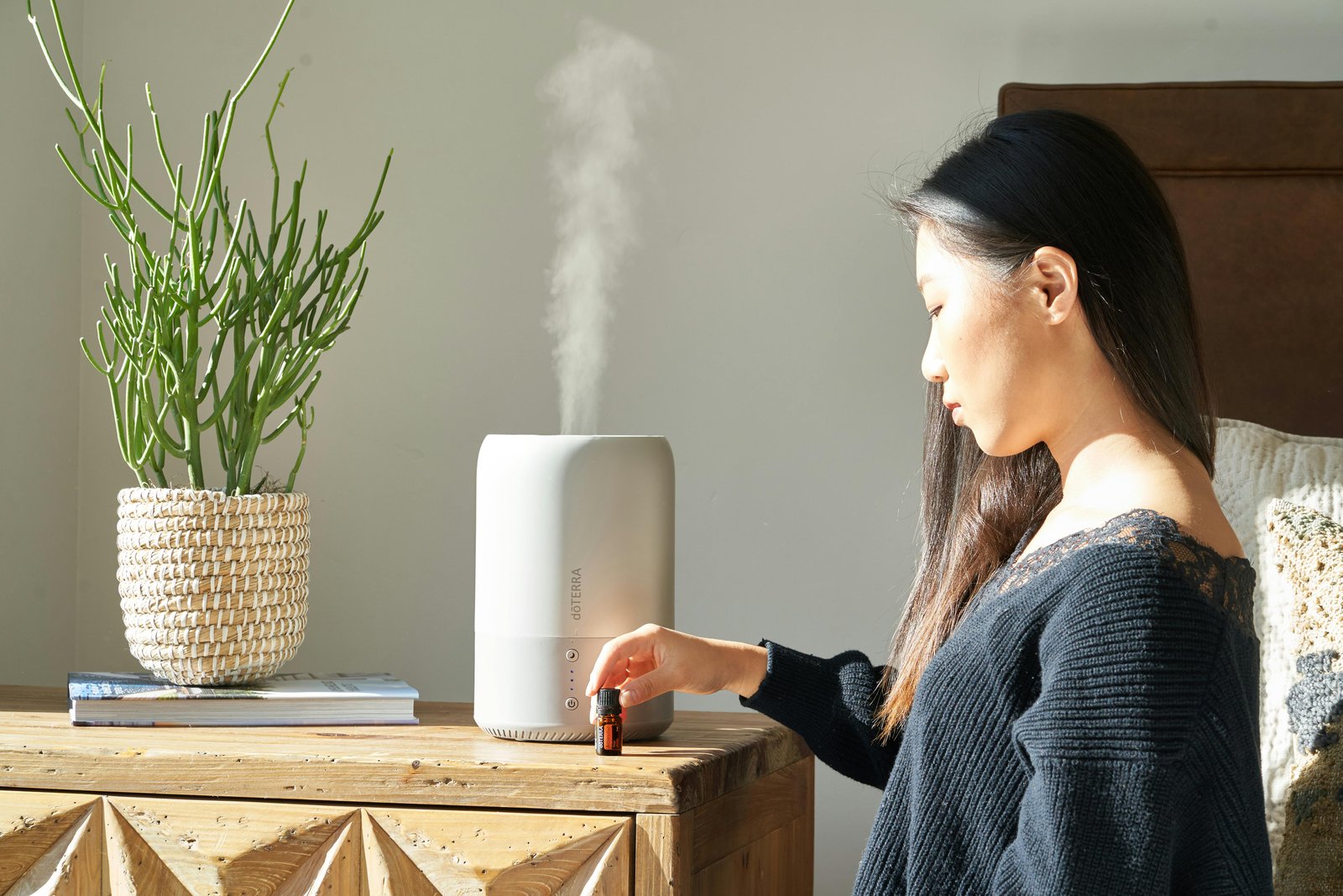 A lady Sitting in Front of a Table Holding Down a Small Medication Bottle on the Table  -How to Stop an Asthma Cough at Night-2204678-10686912.jpg