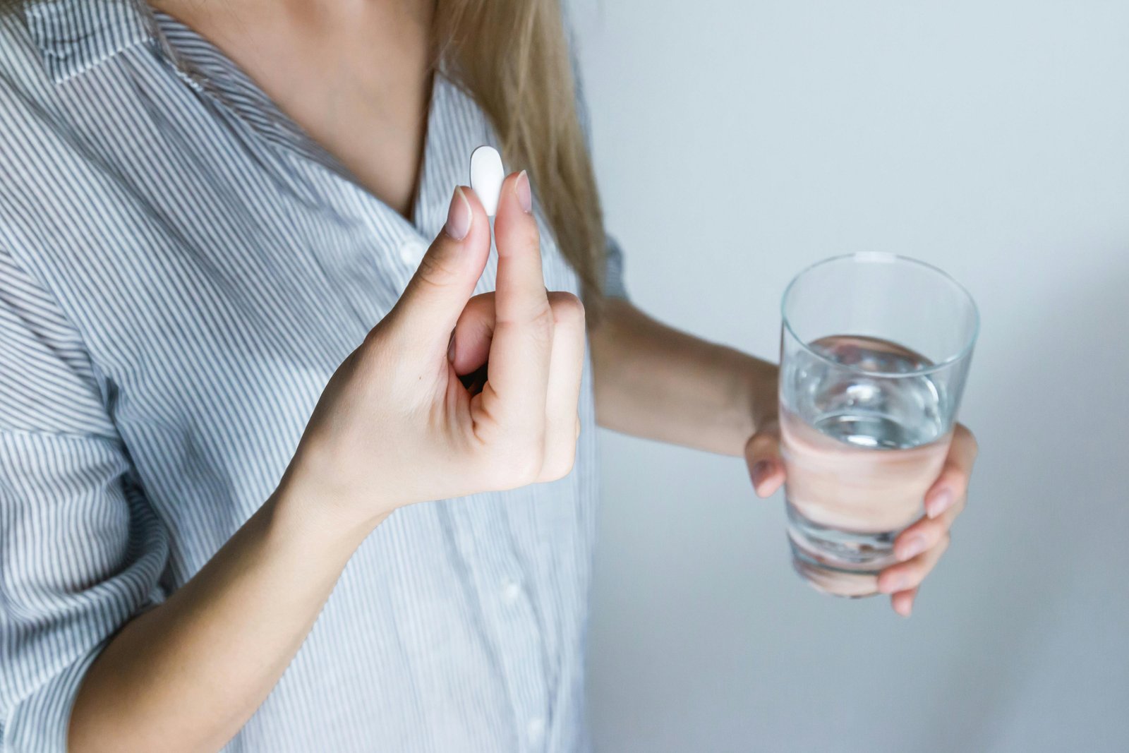 A Lady with a Pill and Glass of Water in Her Hands-147458-576831.jpg