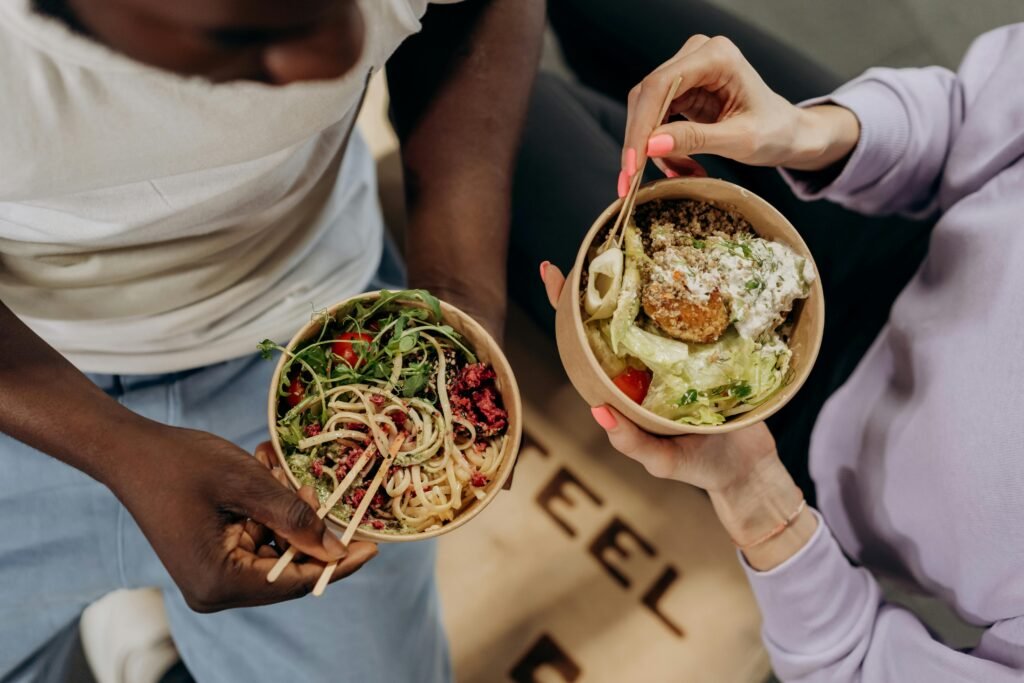 Two People Carrying their Bowls of Food-Obesity and Weight Management