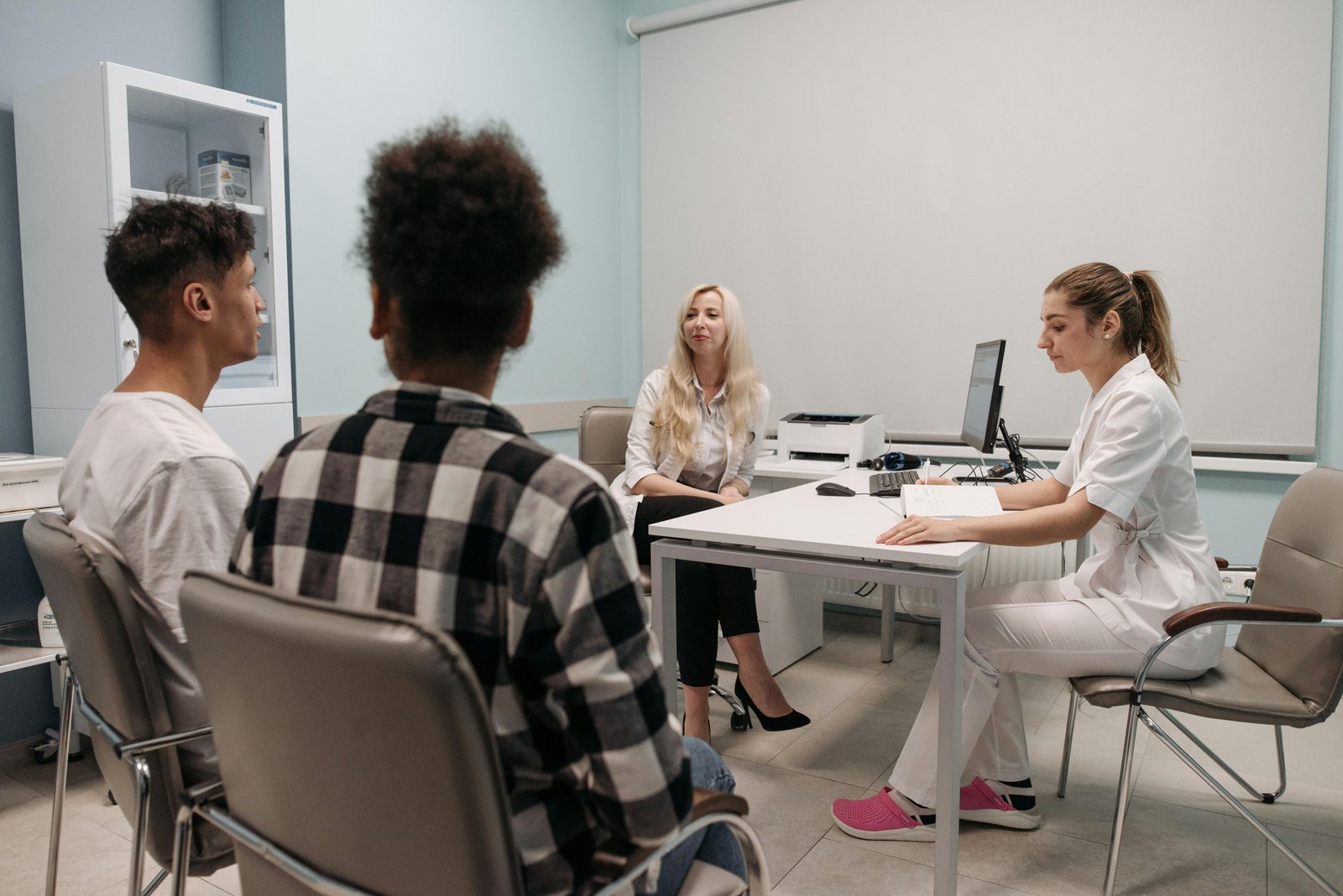 Two Medical Attendants Having a Discussion with a Couple-7108319.jpg