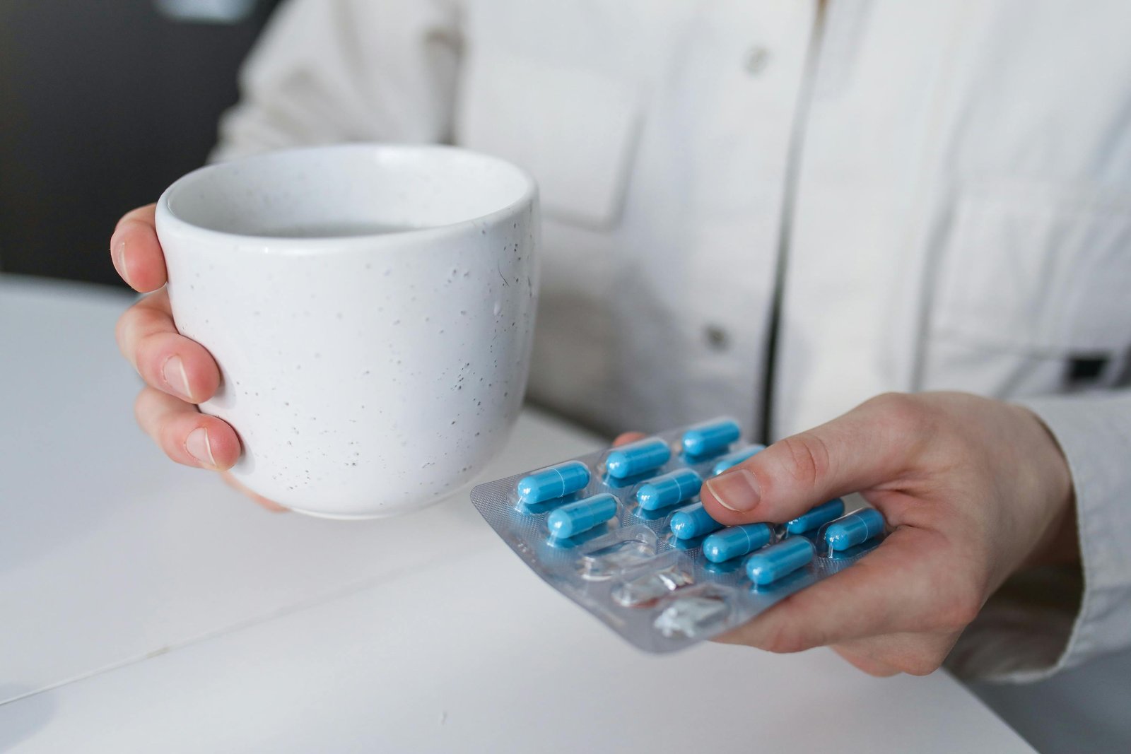 A Hand Holding a Cup of Water and Tablet Medication on the other-Weight Management Medications